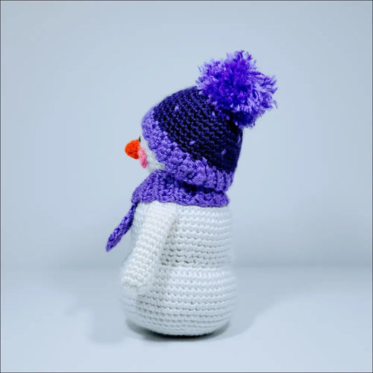 Cute crochet snowman with a purple hat, scarf, and a fun red nose