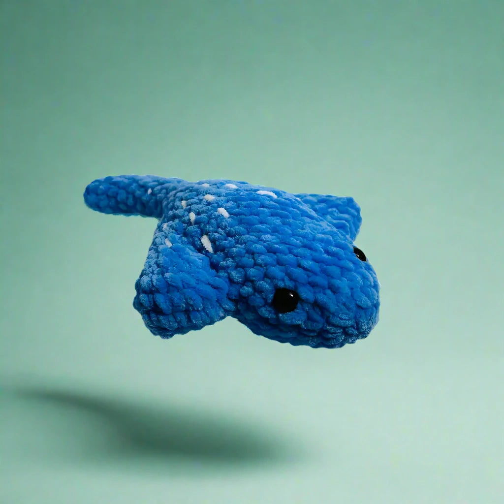 Blue knitted manta ray toy snake with black bead eyes adds ocean vibes