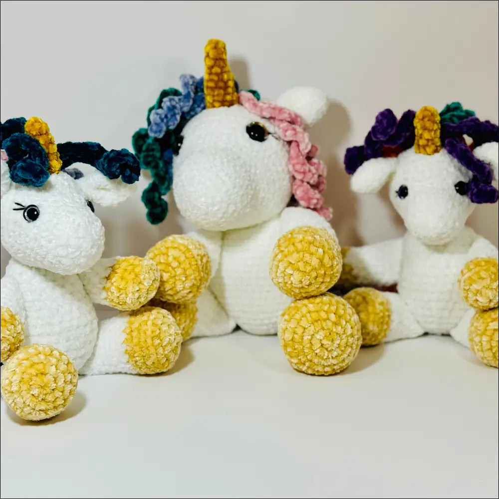 Three colorful unicorn plush toys with golden horns for cozy cuddles at checkout