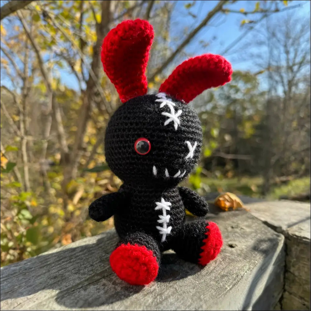 Crocheted black and red zombie bunny plush toy perfect for fun adventures and cuddles