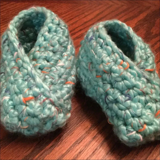 Light blue crocheted baby booties with orange flecks, perfect cozy baby slippers