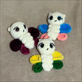 Three colorful butterfly-shaped hair ties on a beige background