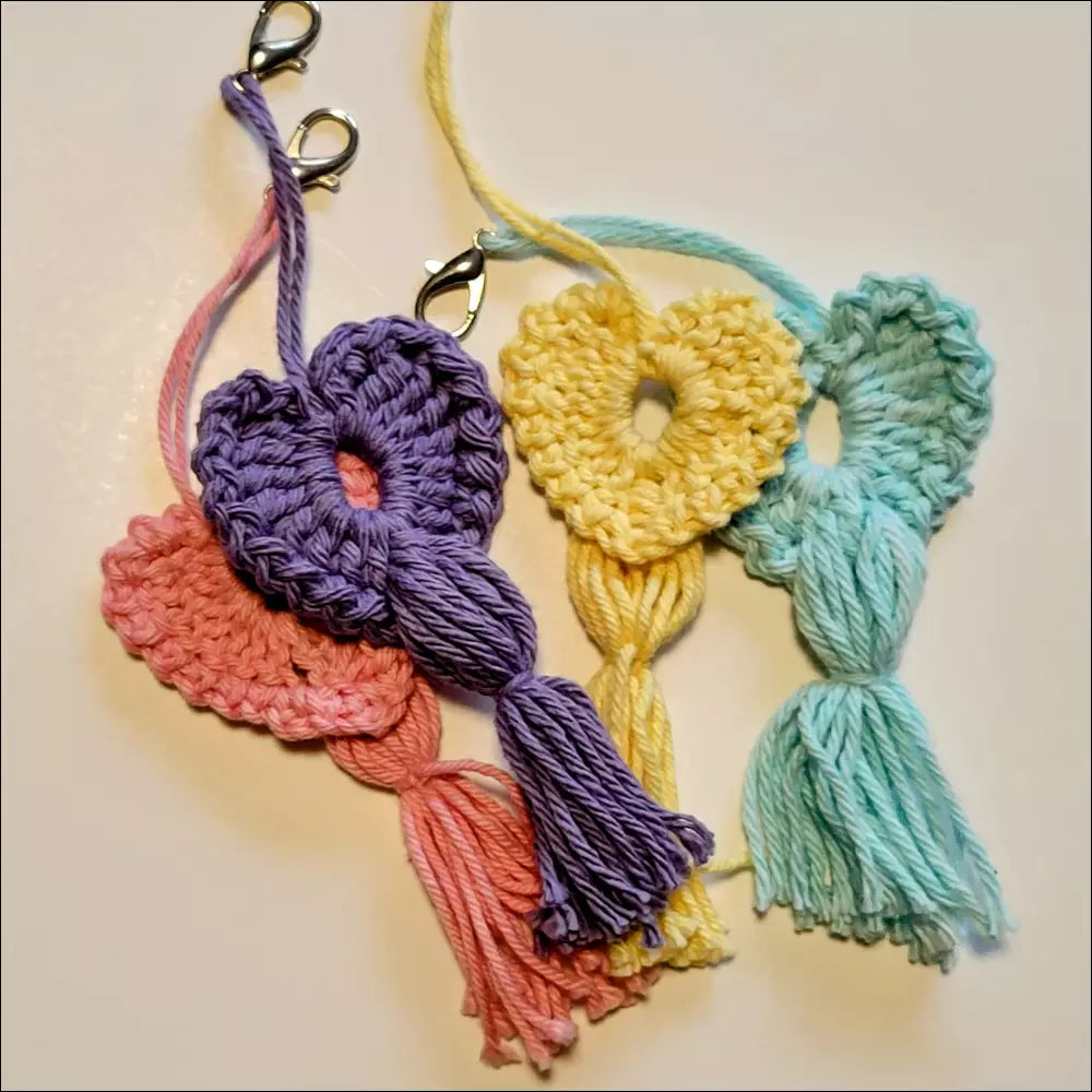 Colorful crocheted heart-shaped keychains with tassels for your coffee cup delight