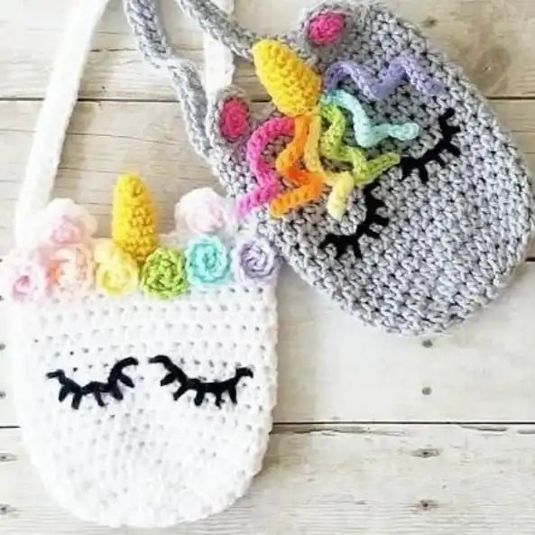 Crocheted unicorn-themed bags with colorful manes and closed eyes.