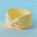 Curved slice of pale yellow cheese beside Cozy Cream Ear-warmer Headband for 6-12 months