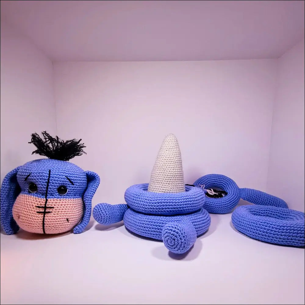 Three cute croches on a shelf with the Eeyore Stacker Toy for fun playtime adventures