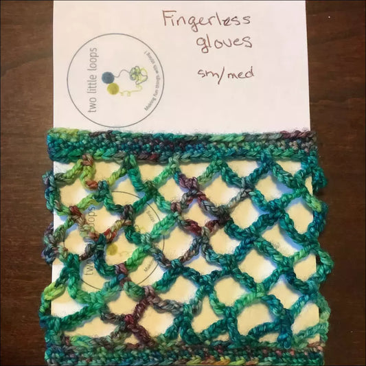 Crocheted fishnet fingerless gloves in green variegated yarn with an open mesh design