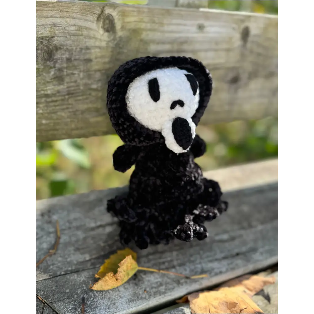 Plush ghost face toy in black robe for spooky Halloween fun and decor