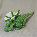 Green dragon toy with white wings on a beige background