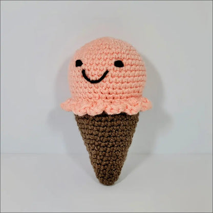 Cute crocheted pink ice cream plush cone with a cheerful face for sweet decor