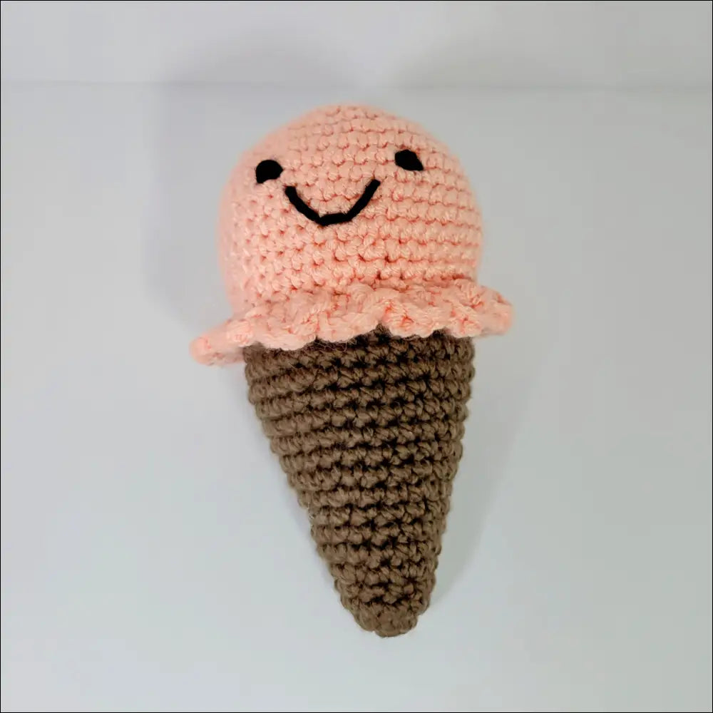 Crocheted ice cream plush with a pink scoop and brown cone for a sweet decor touch