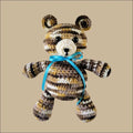 Crocheted Jeremy Bear with striped fur and blue ribbon for cozy fun on the go
