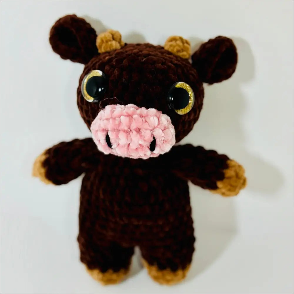 Crocheted brown teddy bear with yellow eyes, part of cozy Jersey Cow plush collection