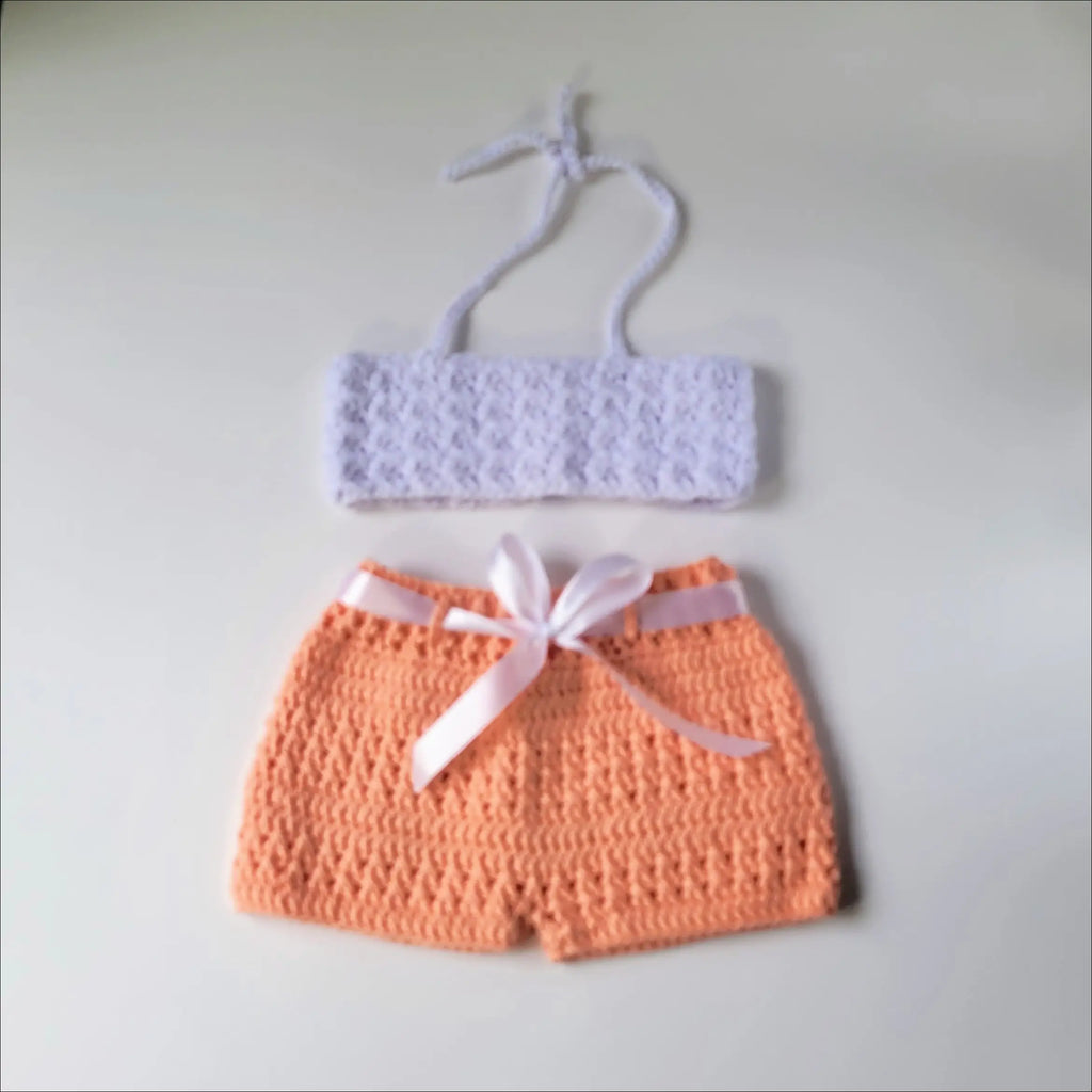 Adorable crocheted baby bikini set featuring a white top and peachy shorts in peachy short set