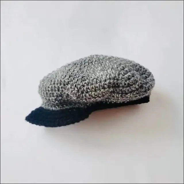Gray knitted newsboy cap with black brim for kids, adding a vintage touch