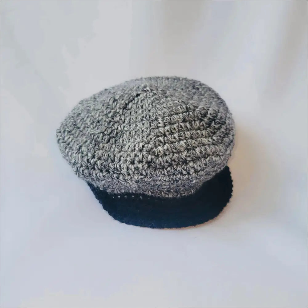 Gray knitted newsboy cap with black brim, perfect for kids’ vintage style