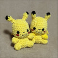 Two yellow plush toys with black ears on a gray background