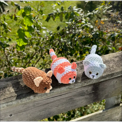 Three cute crocheted cat toys on wood, perfect for snuggling with your plump kitty