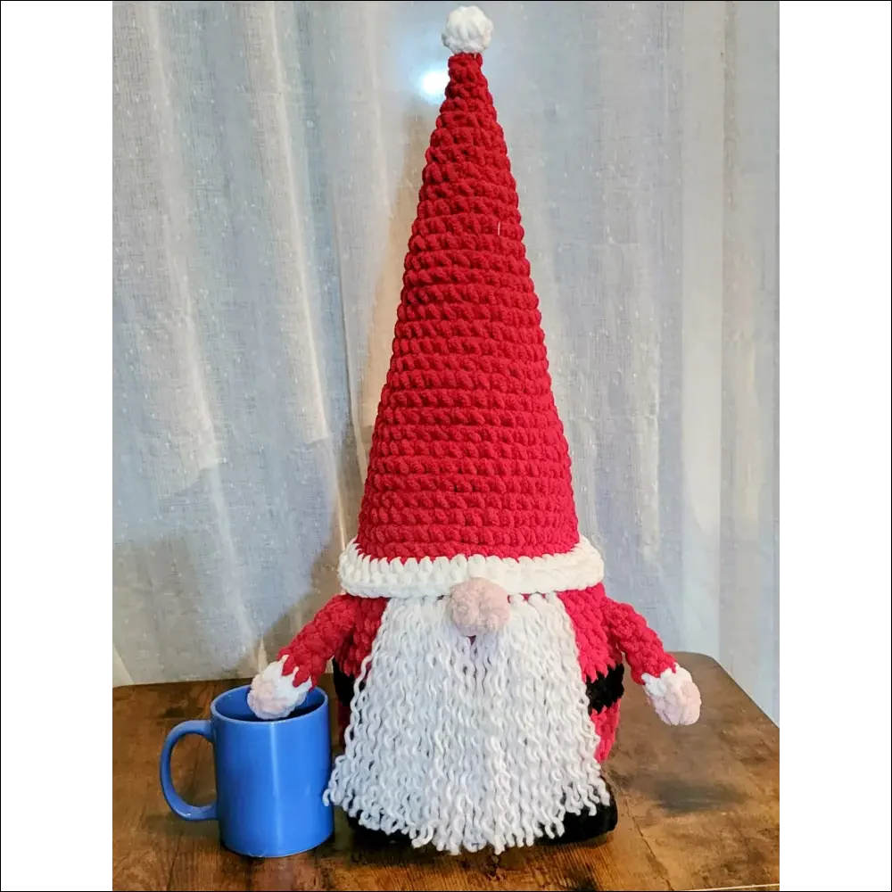 Crocheted Santa Gnome with red hat, white beard, and blue mug for holiday cheer decor