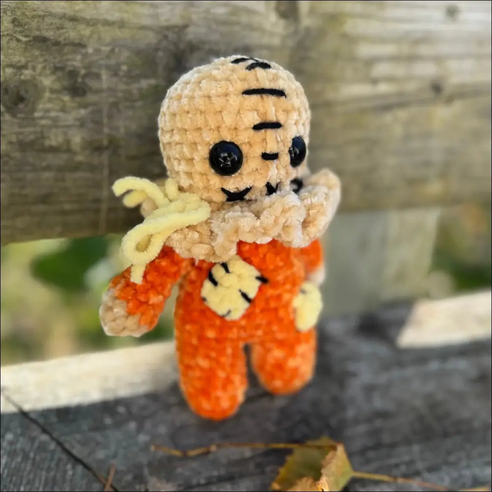 Crocheted Scary Sam doll in orange overalls for spooky Halloween fun