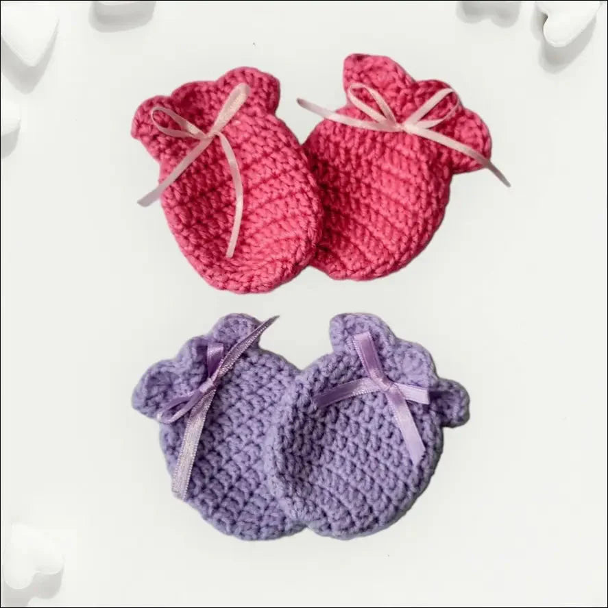 Two pairs of pink and purple crocheted baby booties next to Cozy Winter Scratch Mitts