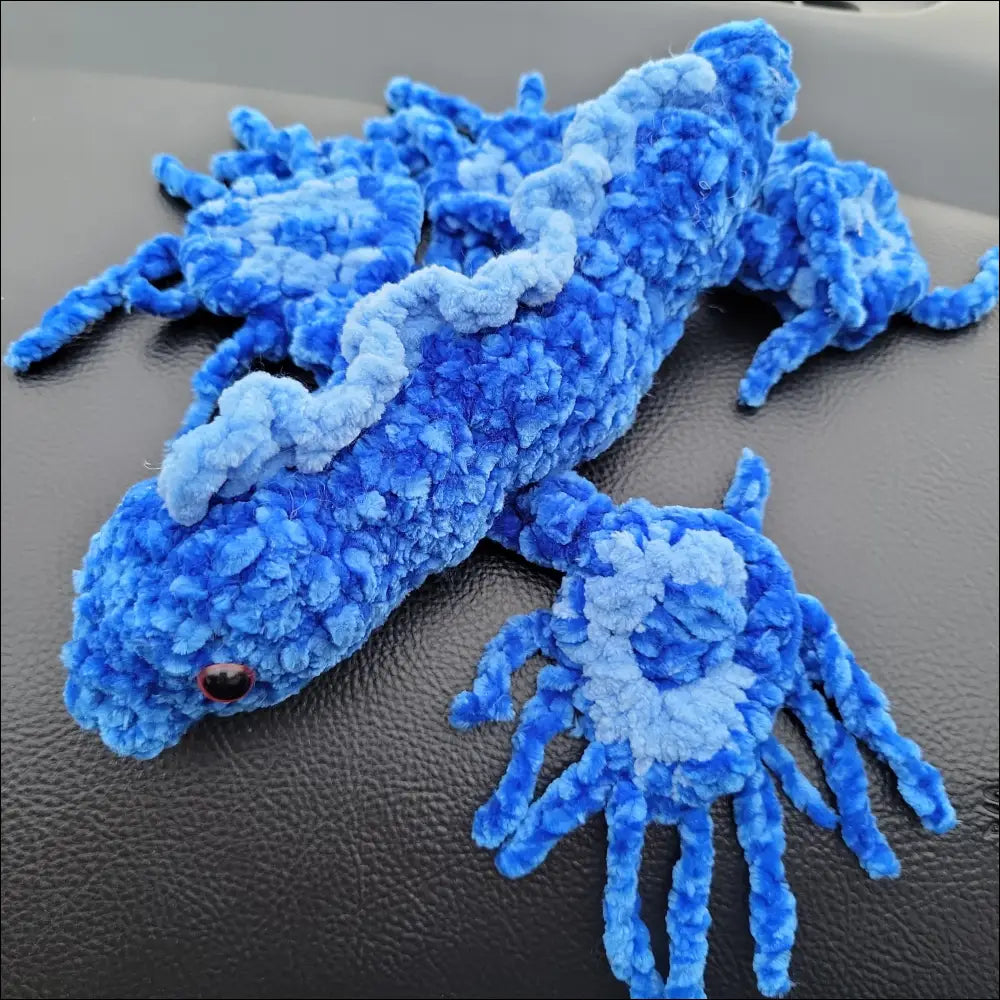 Close up of a blue stuffed lizard from Handcrafted Senior Makes Sea Slug and Latte Cup Toys