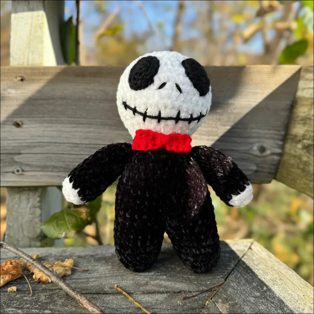 Crocheted Skellington plush toy with a red bow tie for Halloween fun and decor