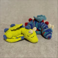 Two crochet dragon toys, one green and one multicolored, on a textured surface.