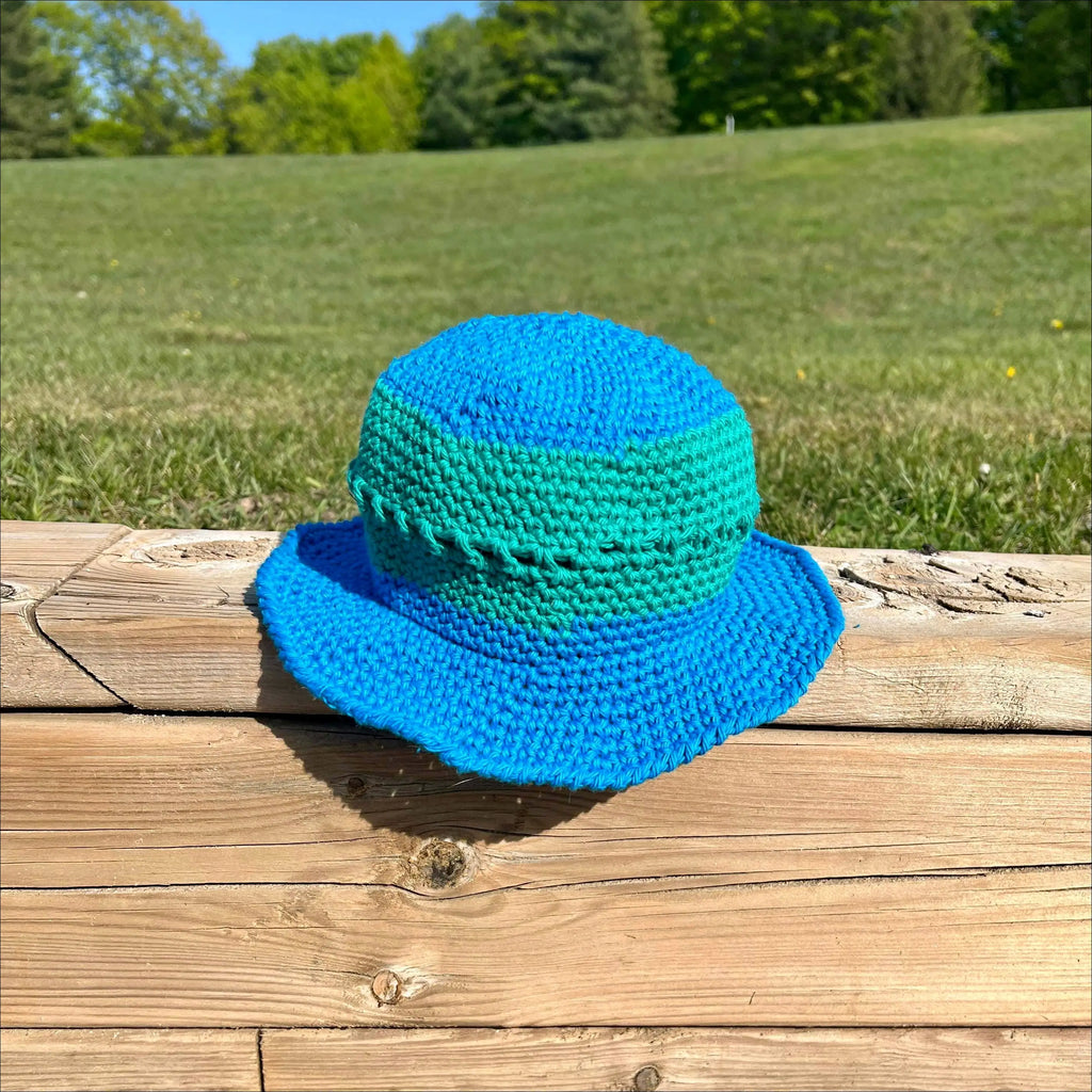 Blue and green crocheted bucket hat from Summer Fun Bucket collection in cream, peach, teal