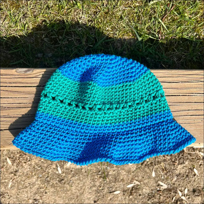 Crocheted blue and teal bucket hat for summer fun in cream, peach, and teal colors