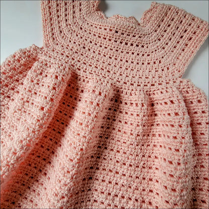 Delicate pink crocheted baby dress, the perfect Sweet Cecilia Dress for special moments