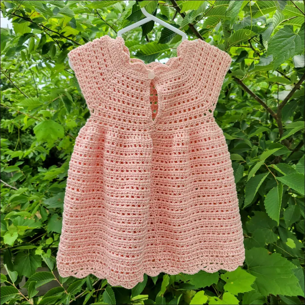 Pink crocheted Sweet Cecilia Dress with short sleeves and keyhole neckline for babies