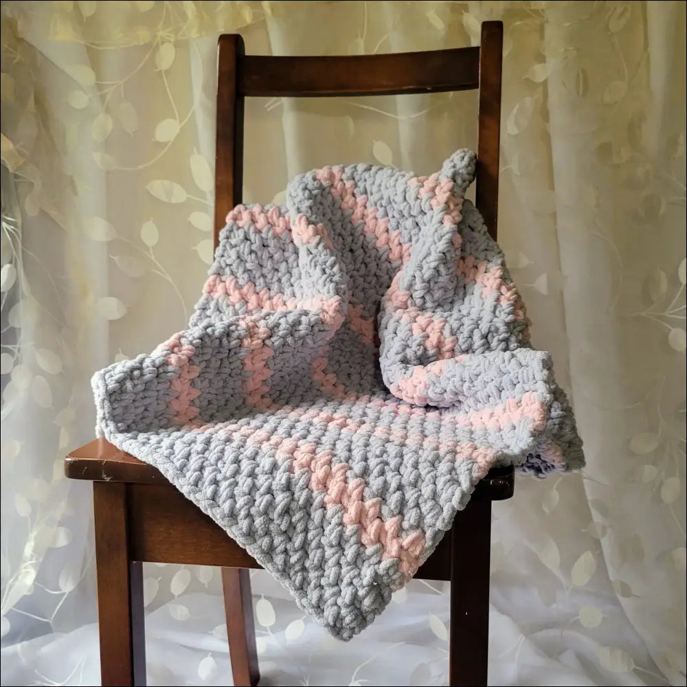 Chunky pink and gray Stripes Baby Blanket on a wooden chair for cozy moments