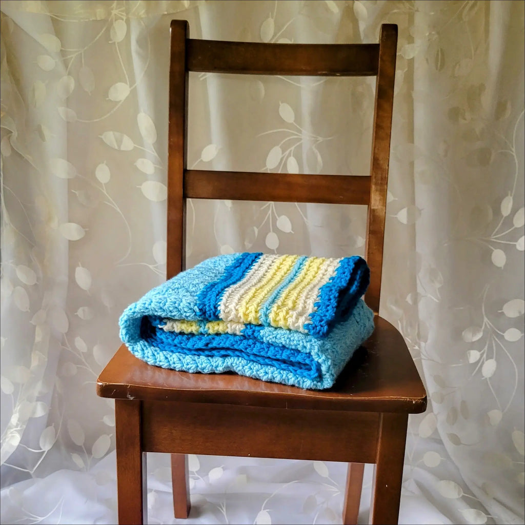 Wooden chair with a cozy textured baby blanket in blue and yellow stripes