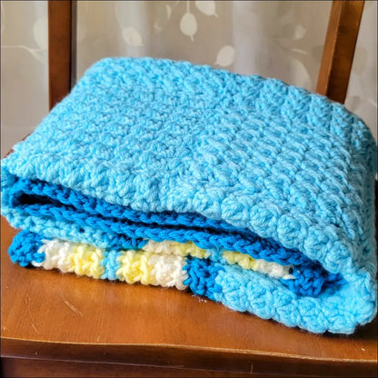 Folded textured baby blanket in blue and yellow for cozy comfort and stylish snuggles