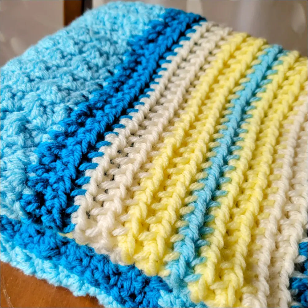 Striped baby blanket textured in blue, yellow, and white for cozy comfort and snuggles