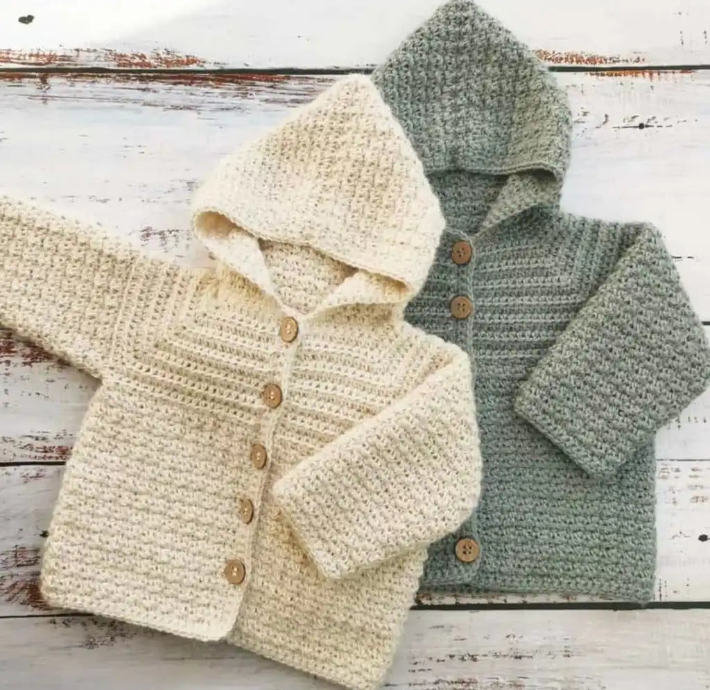 Two knitted baby hooded cardigans in cream and sage green colors.