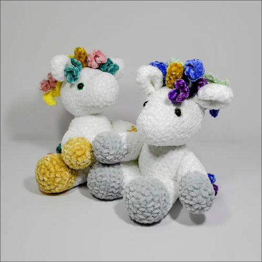 Two cute white stuffed unicorns with flower crowns, perfect for cozy cuddles at checkout