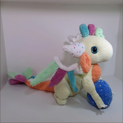 Colorful Winged Dragon Plush sitting on a white surface for imaginative play fun