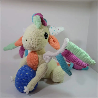 Stuffed dragon plush sitting on white surface for magical adventures and playtime fun