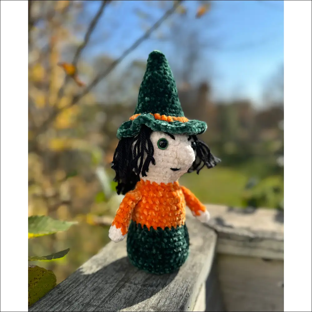 Crocheted doll in green hat and outfit, perfect for purple plush witches decor