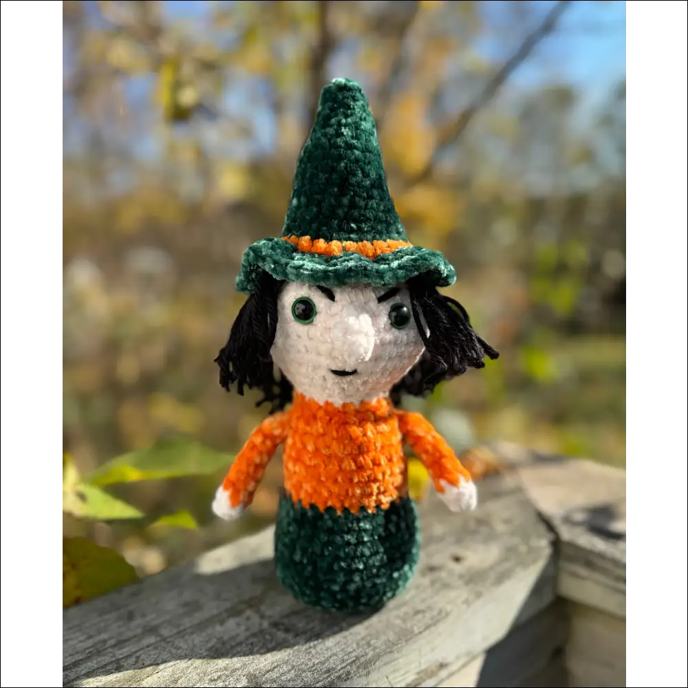 Crocheted witch doll with green hat and orange body from Purple Plush Halloween Decor