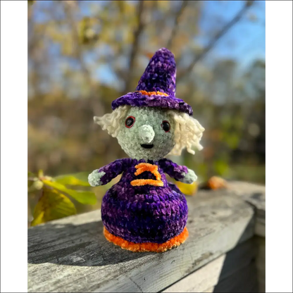 Crocheted witch doll with purple hat, perfect for spooky Halloween decor and calculated shipping