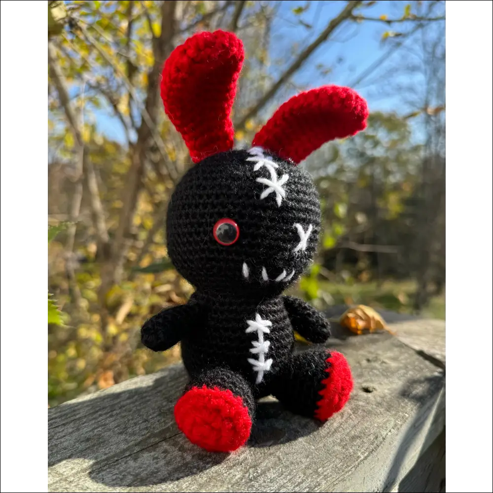 Crocheted black and red zombie bunny plush toy perfect for fun adventures and cuddles