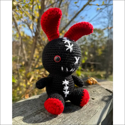 Crocheted black and red zombie bunny plush toy perfect for fun adventures and cuddles